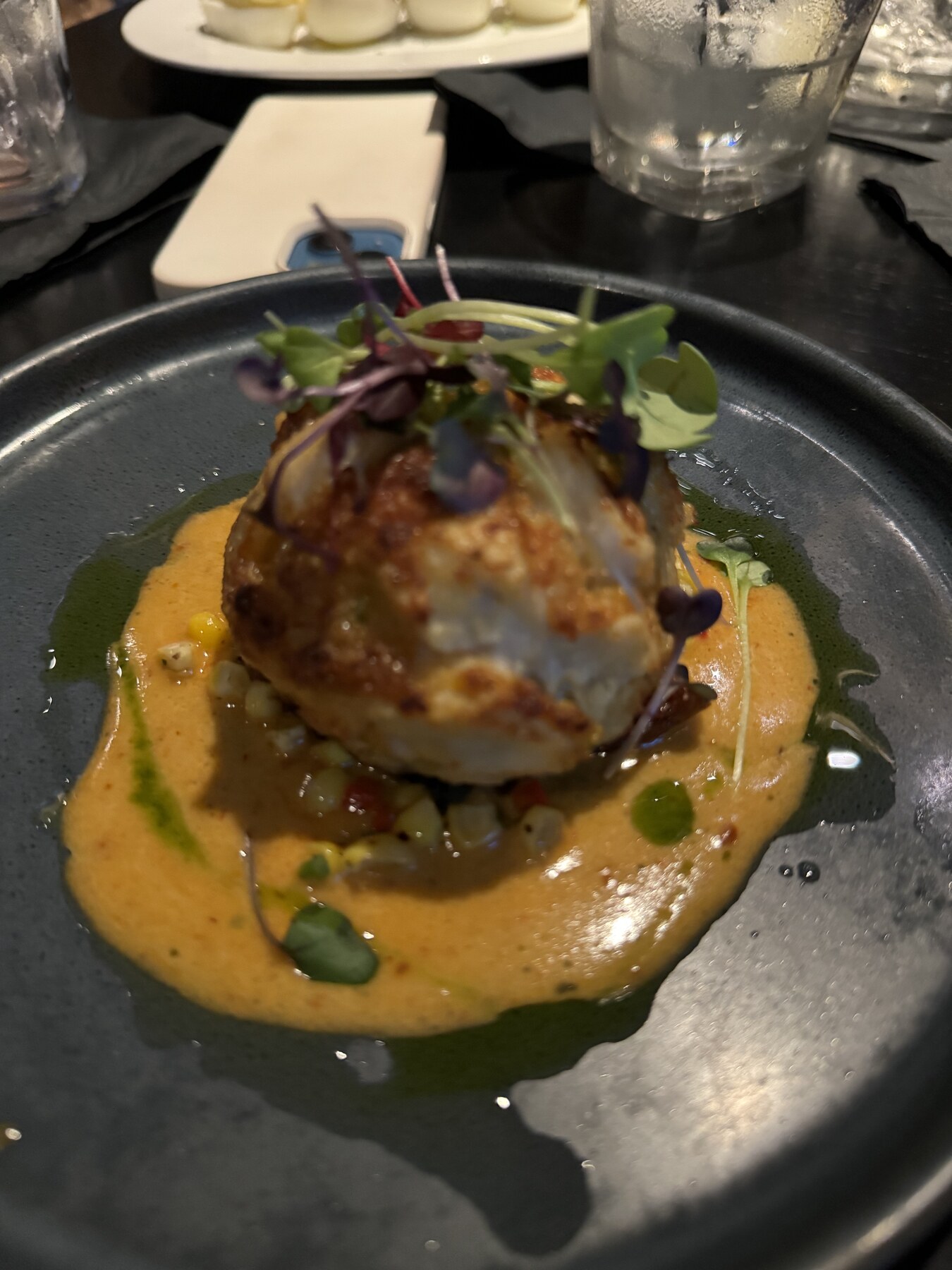 Chef-composed entrée with sauce and delicate herbs