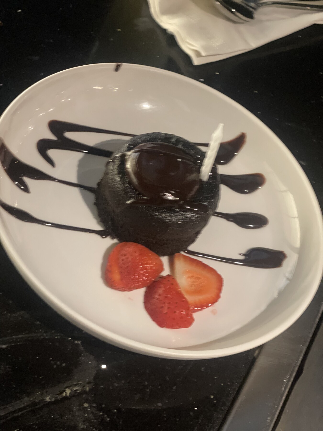 Chocolate dessert plated with berries and artistic sauce