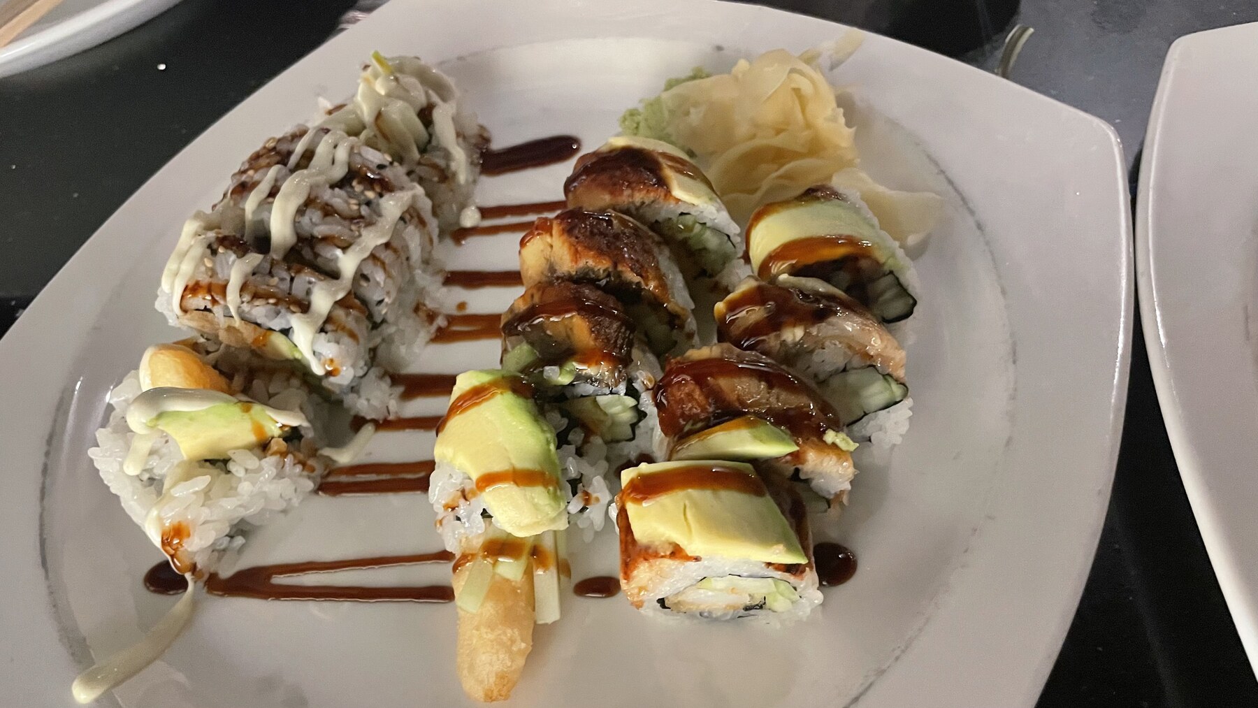 Modern sushi roll selection presented on a white platter
